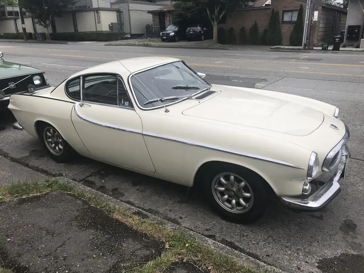 A cream Volvo P1800 coupe